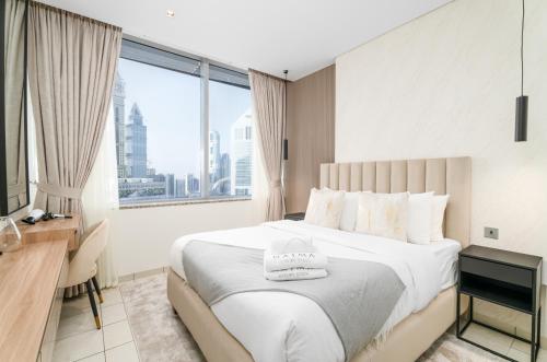 迪拜Nasma Luxury Stays - Elegant 1BR With Stunning View of Park Avenue的一间卧室设有一张大床和大窗户