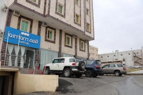 艾卜哈قمم بارك Qimam Park Hotel 4的停在大楼外的一组汽车