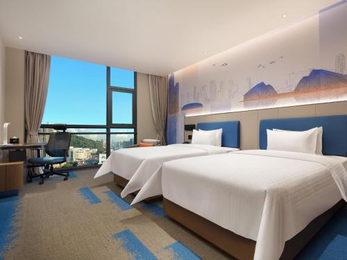 深圳深圳宝安机场希尔顿欢朋酒店的酒店客房配有两张床和一张书桌