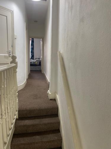 伦敦Confortable and central room的房屋内有楼梯的长走廊