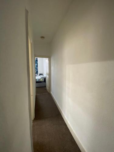 伦敦Confortable and central room的一条带白色墙壁和白色走廊的走廊