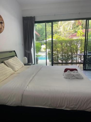 拉威海滩Lotus Bleu Resort & Restaurant的卧室设有一张白色大床和大窗户