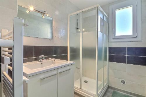 勒格罗-迪鲁瓦Appartement T3 moderne au Grau du roi的一间带水槽和淋浴的浴室