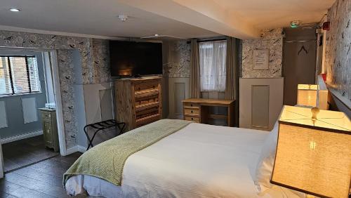 埃文河畔斯特拉特福College Arms的一间卧室配有一张大床和电视