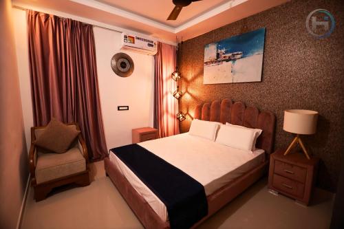 奎隆Holiday Island in Kollam, Nearby Varkala的一间小卧室,配有一张床和一把椅子