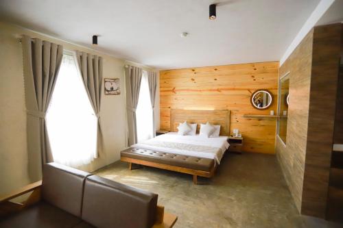 归仁Rustic Hotel Quy Nhon Powered by ASTON的一间卧室配有一张床和一张沙发