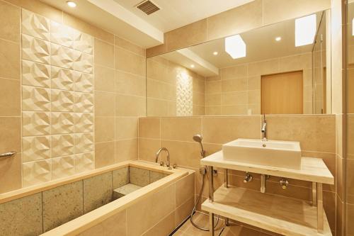 东京高轮大王子酒店的浴室配有盥洗盆和浴缸。