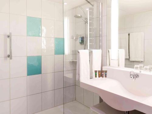 纽伦堡诺沃特酒店纽伦堡展览中心店的白色的浴室设有水槽和淋浴。