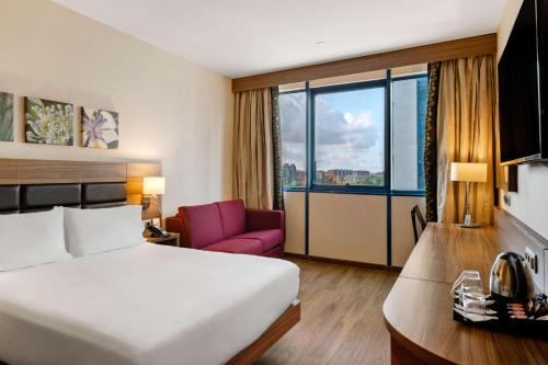 塞维利亚塞维利亚希尔顿花园酒店的酒店客房设有一张床和一个大窗户