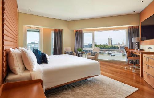 伦敦伦敦公园广场滨河酒店的酒店客房配有一张床、一张书桌和一间厨房。