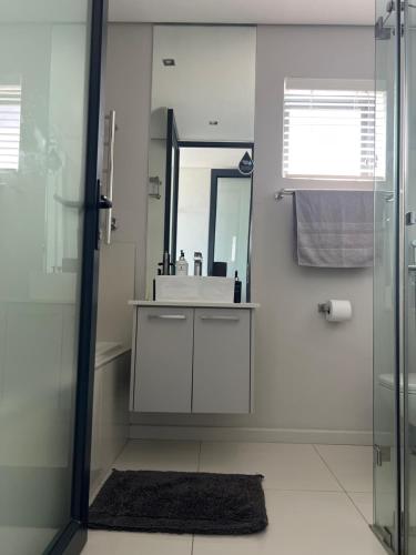 布鲁堡史特兰Blouberg Luxury Beachfront Apartment的一间带水槽和镜子的浴室