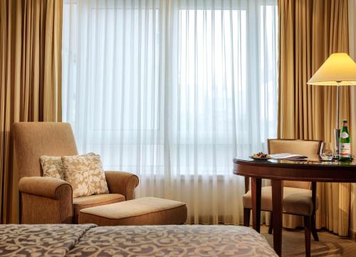 威斯巴登纳索尔霍夫酒店的酒店客房配有书桌、椅子和床。