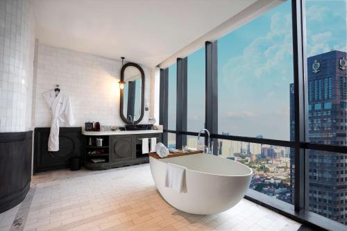 雅加达The Orient Jakarta, a Royal Hideaway Hotel的带浴缸的浴室和大窗户