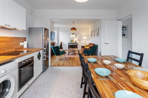 蓬托尔松Loft british au pied du Mont !的厨房、带木桌的客厅和用餐室