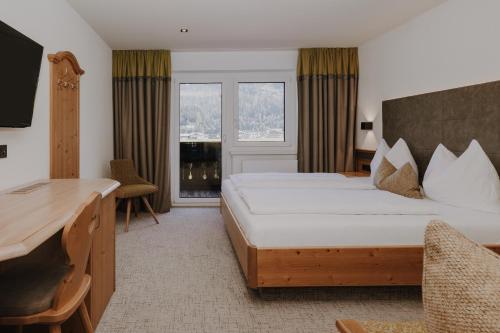 弗拉绍B&B Hotel Die Bergquelle的配有一张床和一张书桌的酒店客房