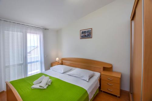 普利莫顿Apartments Jasna的一间卧室配有一张带两条白色毛巾的床
