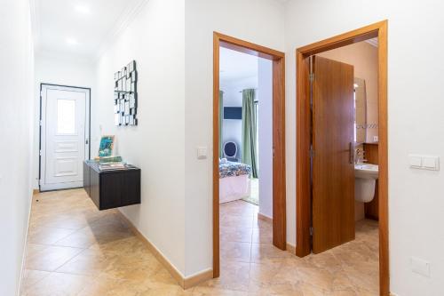 英雄港Chalé d'Angra Guest House的带镜子的走廊和浴室