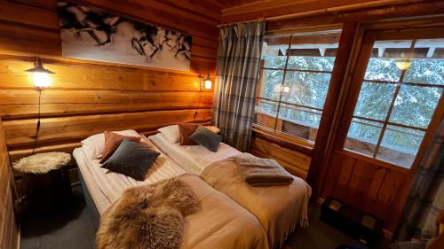 鲁卡Basecamp Oulanka的小木屋内一间卧室,配有两张床