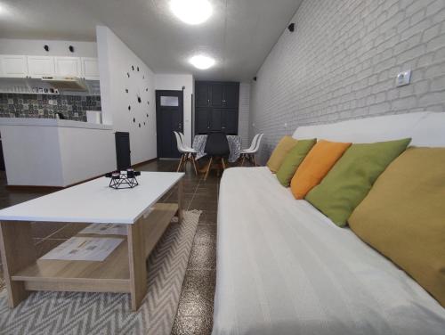 拉夫达Апартамент Фамилия 100м от морето в Равда的客厅配有带色彩缤纷枕头的白色沙发