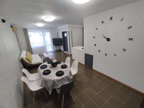 拉夫达Апартамент Фамилия 100м от морето в Равда的客厅配有桌子和墙上的时钟