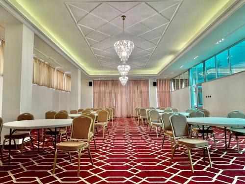 亚的斯亚贝巴Base Ethiopia International Hotel的一间会议室,配有桌椅和吊灯