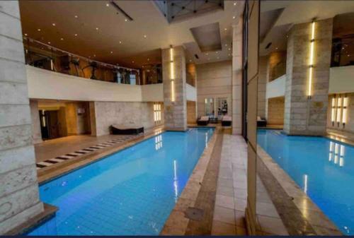 约翰内斯堡Luxury & Breathtaking Sandton & JoburgAmazing View的一座大型游泳池,位于一座带大型游泳池的建筑中