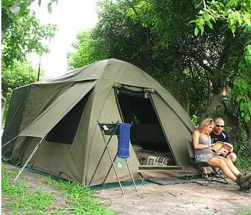 LushotoCamping Magamba Forest的坐在帐篷前的男人和女人