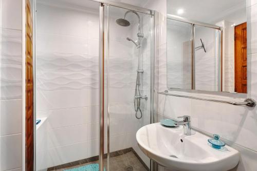 圣米格尔德阿沃纳Blue Dream Pebble Beach的白色的浴室设有水槽和淋浴。