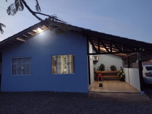 南圣弗朗西斯科Casa Praia Ubatuba Sâo Francisco do Sul 3 quartos的前面有长凳的蓝色房子