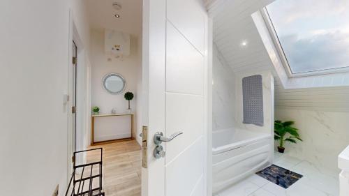 伦敦Penthouse Style Apartment的设有带步入式淋浴间和天窗的浴室