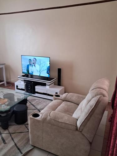 马查科斯Tirisi Homes的带沙发和平面电视的客厅