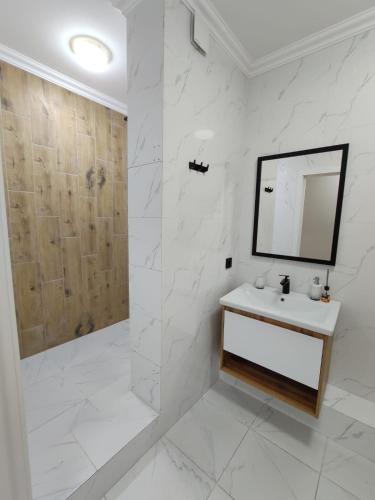 阿拉木图Красивая новая квартира в центре города的白色的浴室设有水槽和镜子