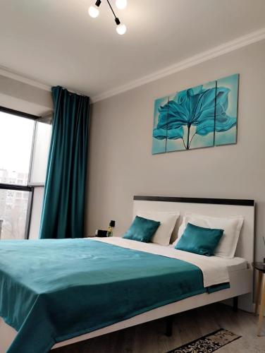 阿拉木图Красивая новая квартира в центре города的一间卧室配有一张带蓝色床单的大床