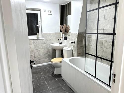 伦敦Luxury 3 Bed Home In London的浴室配有卫生间、浴缸和水槽。