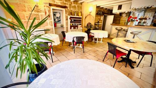 布里夫拉盖亚尔德Chambres d'hôtes Andrea的一间设有桌椅的餐厅,以及一间种植了植物的餐厅