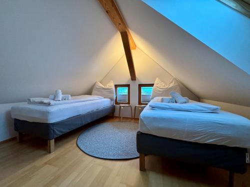 多恩比恩Charmantes Bauernchalet Alois的阁楼卧室配有两张床和蓝色地毯。