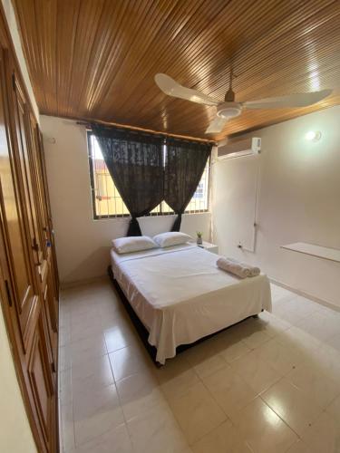 卡塔赫纳Habitaciones cerca al aeropuerto 2的一间卧室设有一张带木制天花板的大床