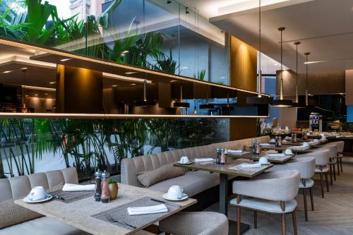 麦德林Hotel York Luxury Suites Medellin by Preferred的用餐室配有桌椅和植物