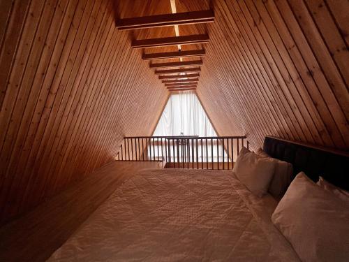 TopçuTopchu Forest Ismayilli的木制客房的一张床位,设有窗户