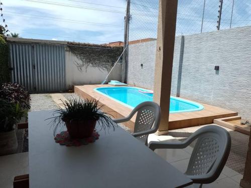 拉巴拉德纳圣安东尼奥Casa Praia Ilha da Croa/Carro quebrado的一张白色的桌子和椅子,以及游泳池