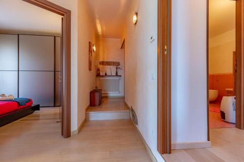布里维奥[Como-Blevio] Suite lake view + private garage的走廊通往带红色床的客厅