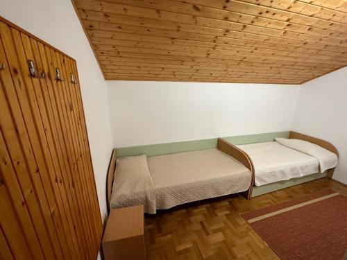 佩特坎内SUNNY PUNTA SKALA APARTMENT的小房间设有床铺和木制天花板