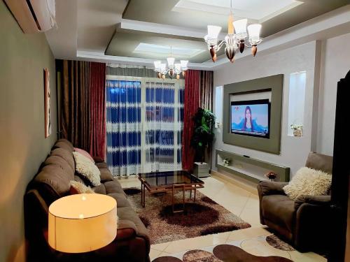 沙姆沙伊赫Sharm Hills Hotel的带沙发和电视的客厅