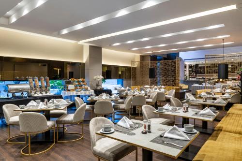 波哥大Hotel 93 Luxury Suites by Preferred的一间在房间内配有桌椅的餐厅
