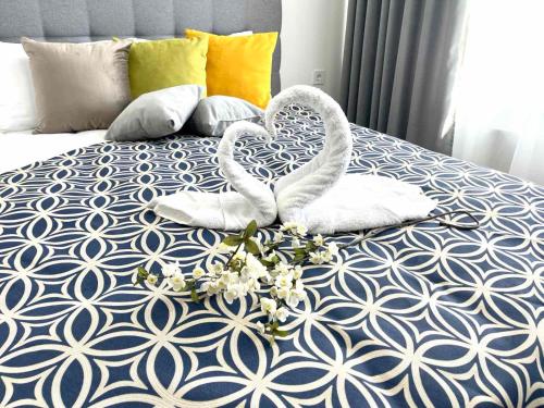 基辅Люкс апартаменти в затишному ЖК бізнес класу的床上的两条天鹅毛巾,上面有鲜花