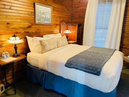 LlanoDabbs Hotel Bed and Breakfast的卧室配有一张床铺,位于带木墙的房间内