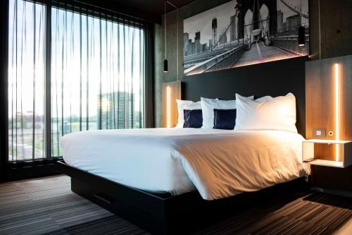 莱维斯Grand Hotel Times Levis的一间卧室设有一张大床和一个大窗户