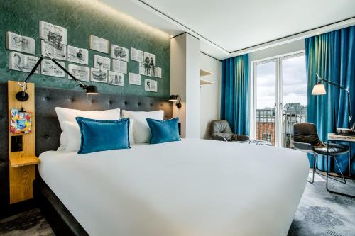 都柏林Motel One Dublin的一间卧室配有一张带蓝色枕头的大床