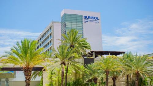 波拉马尔SUNSOL UNIK Luxury Hotel的一座棕榈树建筑