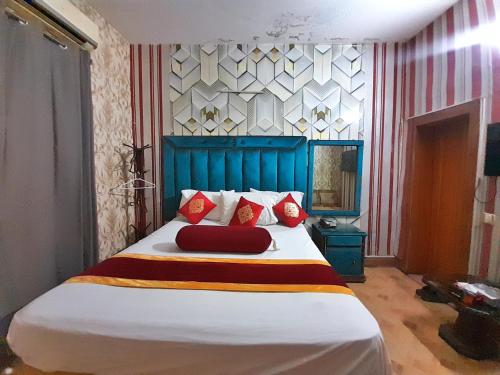 拉合尔Hotel Super Seven的一间卧室配有一张带红色枕头的大床